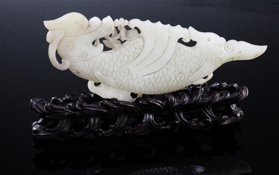 A Chinese pale celadon jade fish-dragon plaque, 18th century, 14cm, with a rosewood stand carved as waves